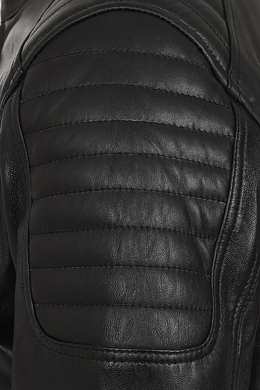 Close-up of a black leather jacket showing the quilted shoulder panel with horizontal stitching and smooth leather texture.